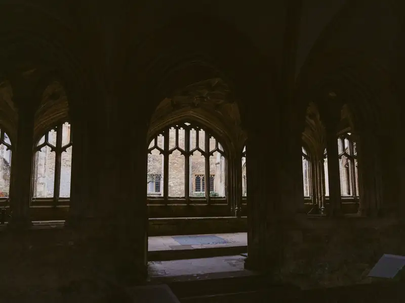 Arched stone windows in a dim university cloister