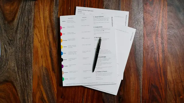Printed forms and a pen on a wooden table