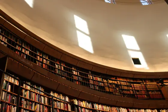 A round library hall with tiered shelves in warm light